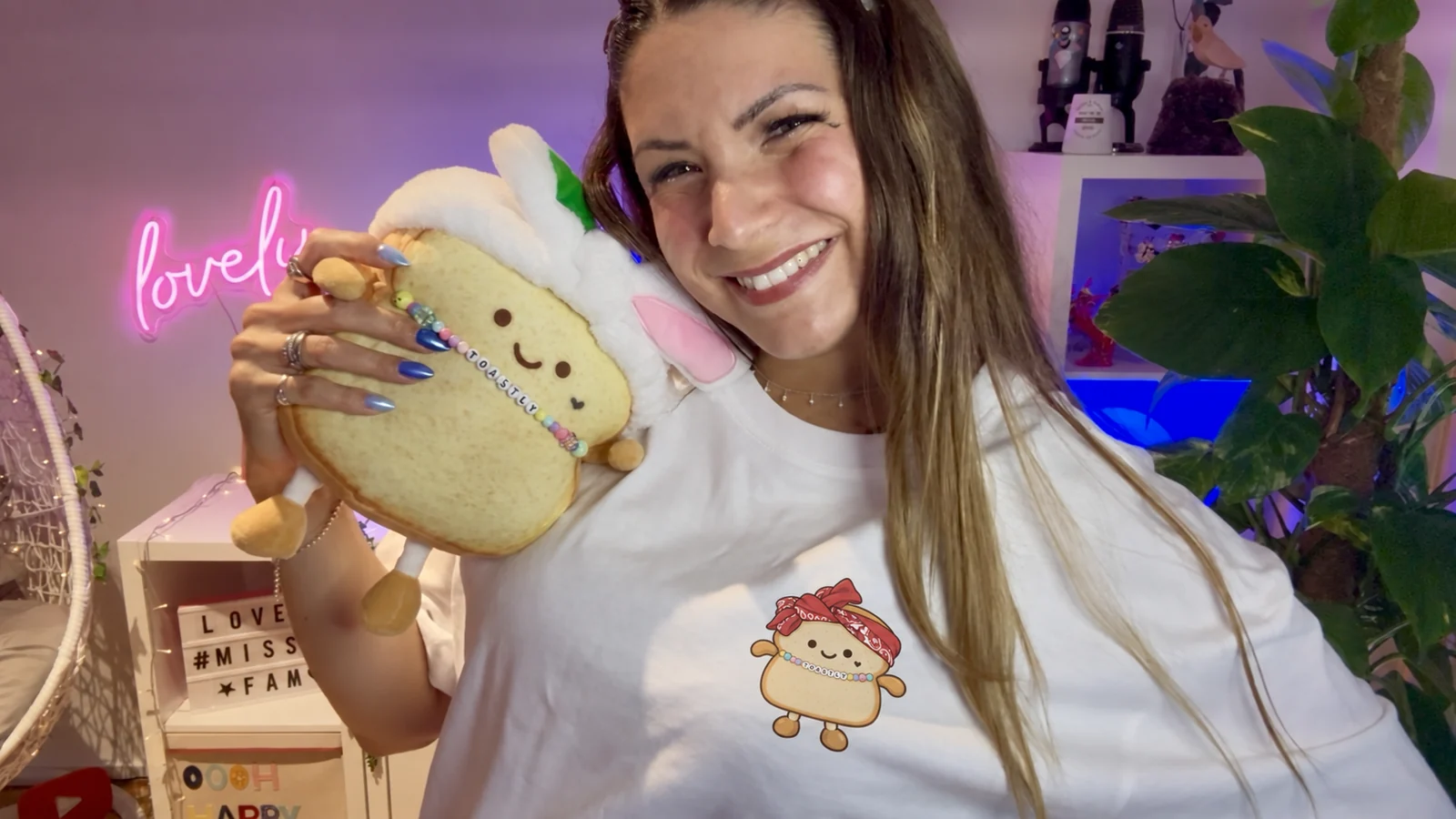 Miss Mi hält das Original-Plüschtier Toastly neben ihr Gesicht. Das neue Comicmotiv auf ihrem Shirt ist digital ergänzt.