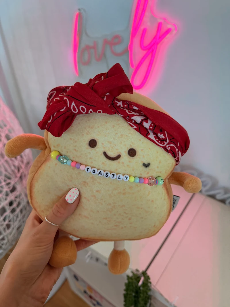Der originale Toastly mit rotem Bandana, Perlenkette und kleinem Herz unter seinem linken Auge.