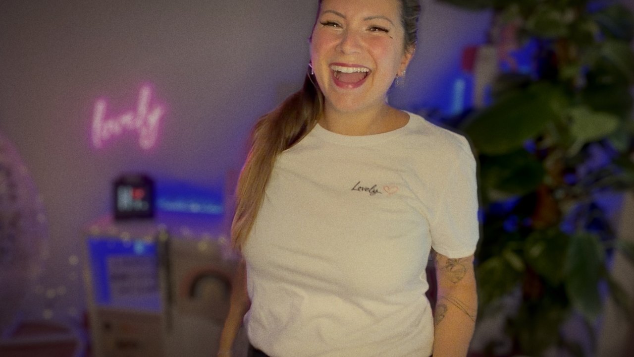 Miss Mi lächelt im weißen Lovely-Shirt in die Kamera.